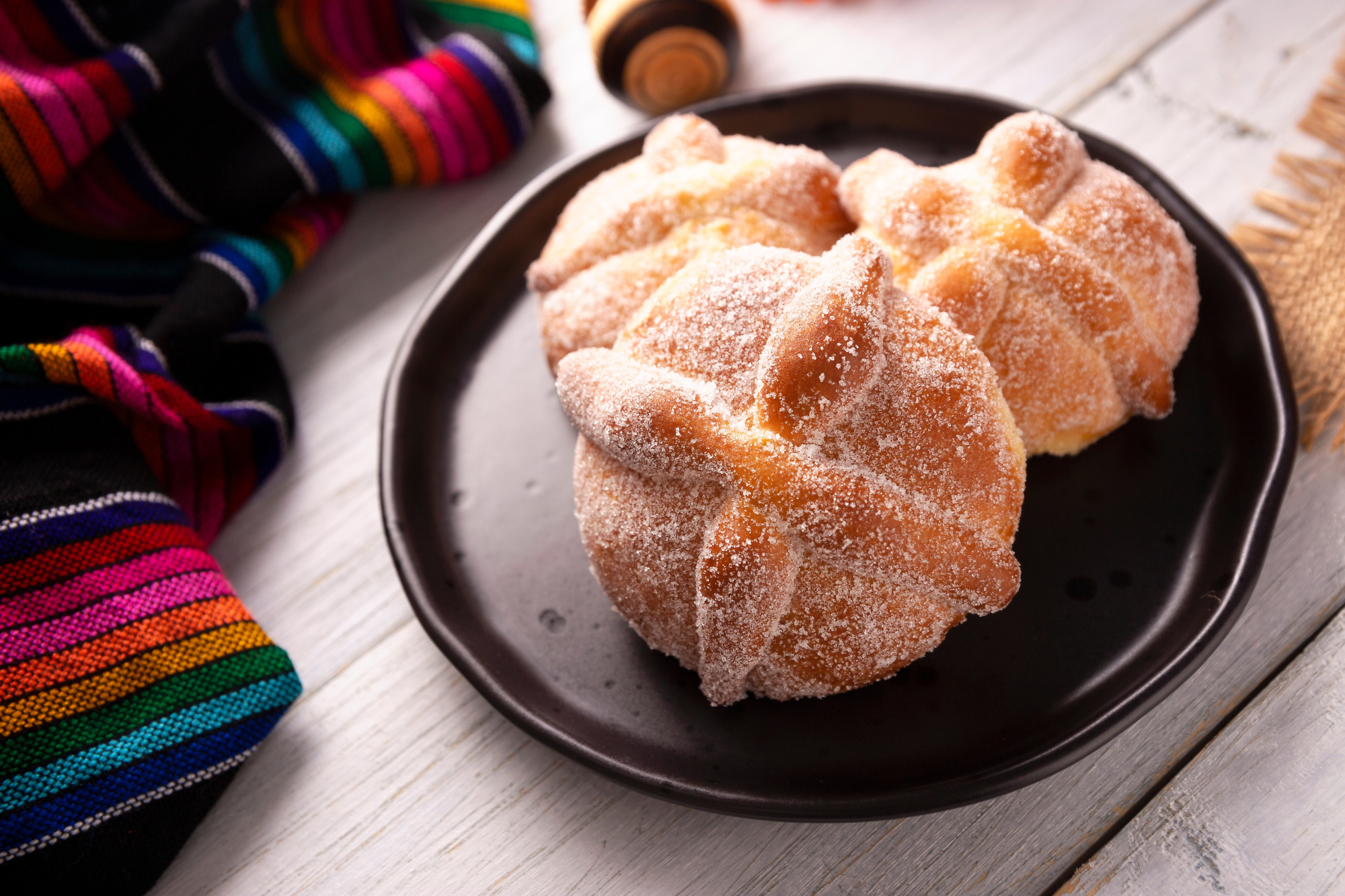 Imagen pan de muerto en plato negro, mexicano