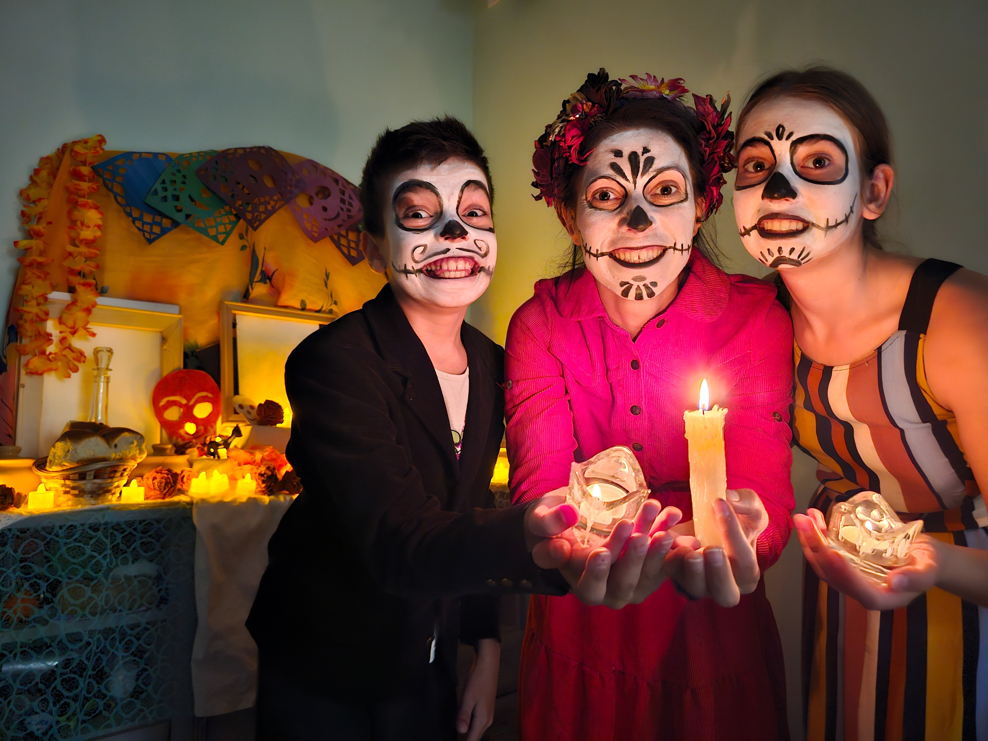 Imagen de familia pintada de calavera, altar de muertos, velas