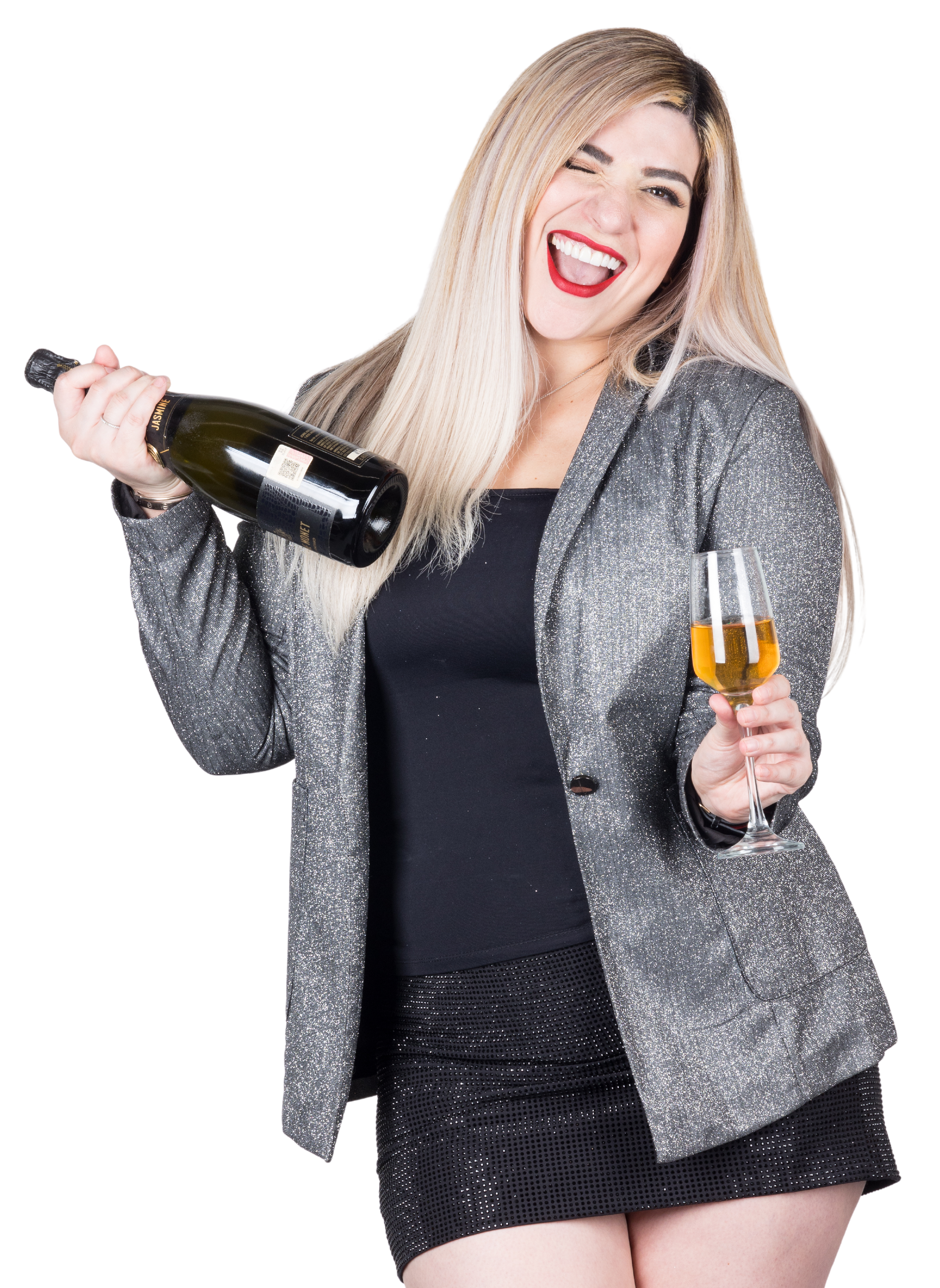 Mujer rubia brindando con copa de vino espumoso y botella, vestida con saco plateado y sonrisa festiva.